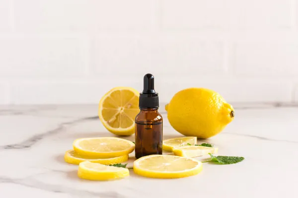 Kosmetik Oder Ätherisches Zitronenöl Einer Flasche Tropfen Auf Dem Hintergrund — Stockfoto