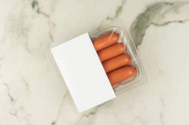 Vakum ambalajında taze çiğ sosisler. Logo tasarımı. en üstteki görünüm