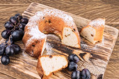 Tahta tahtada kuru üzümlü dilimlenmiş kek ve kırsal bir masa. Ev yapımı kekler.