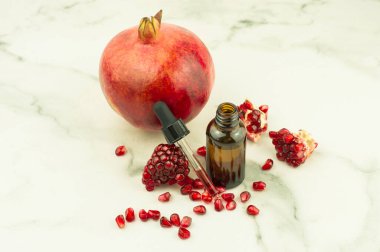 Günlük özbakımda ilave su için nar yağıyla doldurulmuş damlatan pipetli kozmetik şişesi.