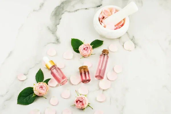 顶部的化妆品和玻璃瓶与瓶塞盖玫瑰水和玫瑰精油 白色背景 — 图库照片
