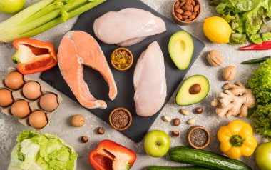 Yüksek miktarda E vitamini ve diyet lifli sağlıklı yiyecekler. Yemek geçmişi. Taze somon bifteği, tavuk fileto, fındık, yumurta. en üstteki görünüm