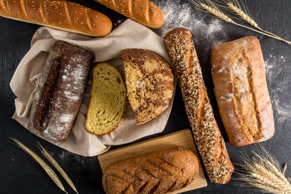 パンの背景 黒を背景に様々な種類の小麦粉で作られたパンの愛 トップビューフラットスタイリング ストック写真