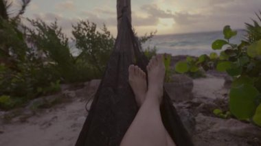 Hamakta güzel tropikal plaj manzaralı orta boy kadın bacakları. Güzel yerler ve seyahat konsepti