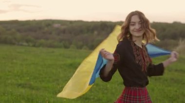 Vyshyvanka 'da Ukraynalı genç bir kadının 4k portresi - Ukrayna ulusal kıyafetleri. Ukrayna bayrağı taşıyor. Özgürlük ve bağımsızlığın sembolü..