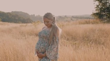 4k slow motion portrait of beautiful happy pregnant woman in countryside during sunset