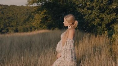 4k slow motion portrait of beautiful happy pregnant woman in countryside during sunset