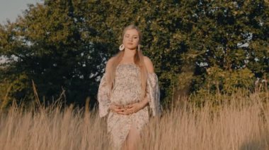 4k slow motion portrait of beautiful happy pregnant woman in countryside during sunset