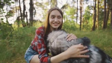 4k slow motion shot of teenage girl playing and having fun with her siberian husky dog. Girl with dog in the forest