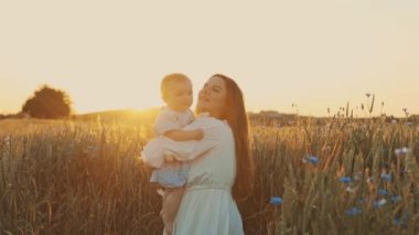 4k slow motion shot of mother and daughter having a picnic outdoors in the field. Playing and having fun with little baby . Happy family concept