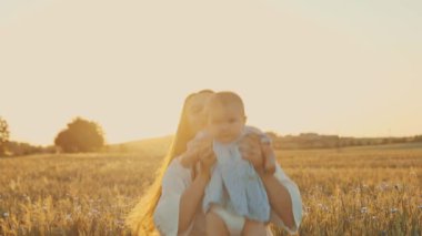 4k slow motion shot of mother and daughter having a picnic outdoors in the field. Playing and having fun with little baby . Happy family concept
