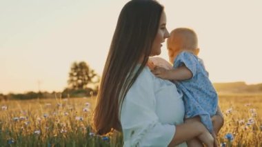 4k slow motion shot of mother and daughter having a picnic outdoors in the field. Playing and having fun with little baby . Happy family concept