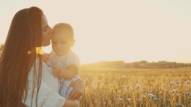 4k slow motion shot of mother and daughter having a picnic outdoors in the field. Playing and having fun with little baby . Happy family concept