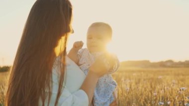 4k slow motion shot of mother and daughter having a picnic outdoors in the field. Playing and having fun with little baby . Happy family concept