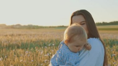 4k slow motion shot of mother and daughter having a picnic outdoors in the field. Playing and having fun with little baby . Happy family concept