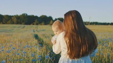 4k slow motion shot of mother and daughter having a picnic outdoors in the field. Playing and having fun with little baby . Happy family concept