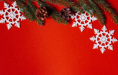 Noel arkaplanı - kırmızı kopya alanı üzerinde çam ağacı dalları, kar taneleri ve dekor 