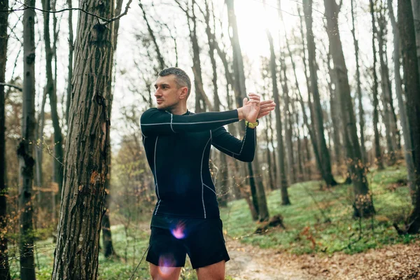 Mężczyzna Rozciągający Się Przed Bieganiem Pięknym Wiosennym Lesie Koncepcja Sportu — Zdjęcie stockowe