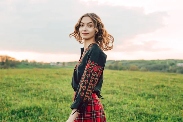 young beautiful Ukrainian woman in vyshyvanka - ukrainian national clothes outdoors in countryside during sunset. Stand with Ukraine