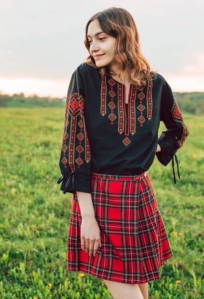 young beautiful Ukrainian woman in vyshyvanka - ukrainian national clothes outdoors in countryside during sunset. Stand with Ukraine