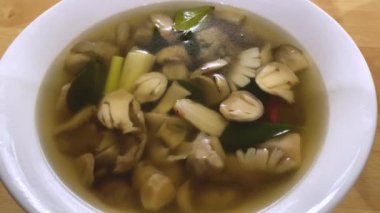 Squeeze the lemon to add flavor to the tom yum clear soup. Popular food of Thailand