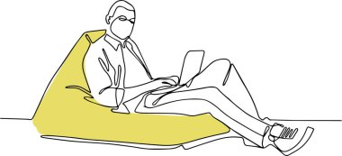 Evde kanepede dizüstü bilgisayar kullanan genç adam