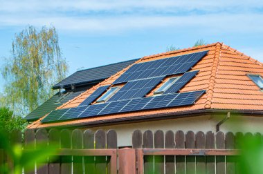 Çatıda fotovoltaik modüller var. Çatı ve duvar üzerinde modern güneş panelleri olan tarihi çiftlik evi.