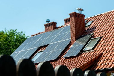 Çatıda fotovoltaik modüller var. Çatı ve duvar üzerinde modern güneş panelleri olan tarihi çiftlik evi.