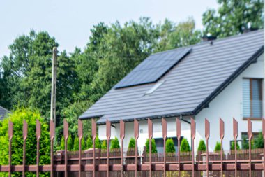 Çatı ve duvar üzerinde modern güneş panelleri olan tarihi çiftlik evi.