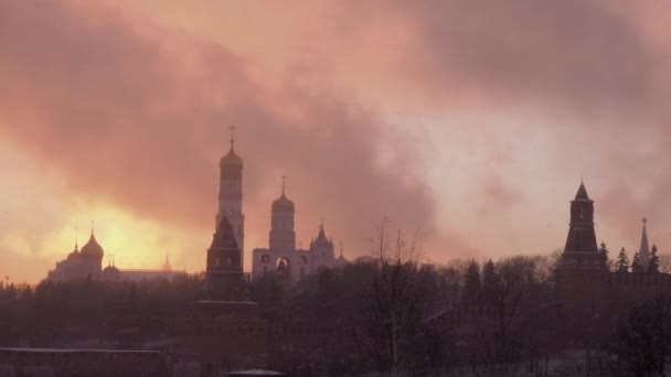 Rusland, Moskou, de Ivan de Grote Kloktoren is een kerktoren in het Moskouse Kremlin. Uitzicht op het Kremlin in een besneeuwde winterdag. De Kathedraal van Vasily de Gezegende bij zware sneeuwstormen — Stockvideo