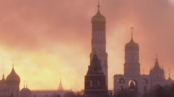 Rusia, Moscú, El Gran Campanario Iván es una torre de iglesia dentro del complejo del Kremlin de Moscú. Ver en el Kremlin en un día de invierno nevado. La Catedral de Basilio el Bendito en el clima de tormenta de nieve pesada — Vídeo de stock