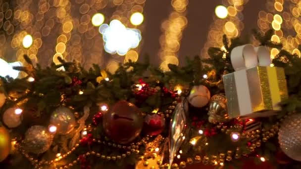 美しいクリスマスのスクリーンセーバー。ストリートシーズンフェアで赤と黄色のボールクリスマスツリーガーランドとギフトボックスの装飾。クリスマスの装飾、クリスマスツリーのおもちゃ-新年の休日の背景 — ストック動画