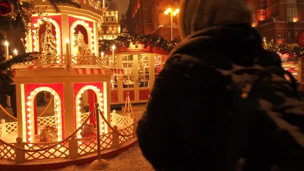Москва-17 грудня 2018: святковий новий рік і різдвяні свята в Сніжному Москві. Натовп людей ходить серед ялинок на Манежної площі біля Червоної площі та Кремля. Яскраві вогні блимають на — стокове відео
