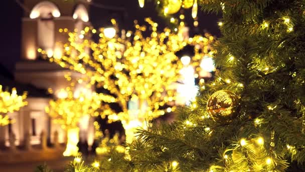 Zamknij choinkę świecącą w nocy. Noworoczna jodła z dekoracjami i oświetleniem. Ozdoby choinkowe tło. Wiele dużych złotych kul na jodle Nowy Rok i Boże Narodzenie — Wideo stockowe