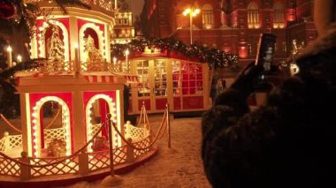 MOSCOW - 17 DEC 2020: Karlı Moskova 'da Yılbaşı ve Noel Tatilleri. Kızıl Meydan ve Kremlin yakınlarındaki Manezhnaya meydanında bir sürü insan fotoğraf çekip Noel ağaçları arasında yürüyor. Parlak