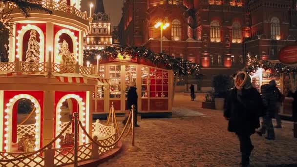 MOSCOW - DEC 17, 2020: Feestelijke nieuwjaars- en kerstvakantie in Snowy Moskou. Een menigte mensen neemt foto 's en wandelt tussen kerstbomen op het Manezjnaja plein bij het Rode Plein en het Kremlin. Helder — Stockvideo