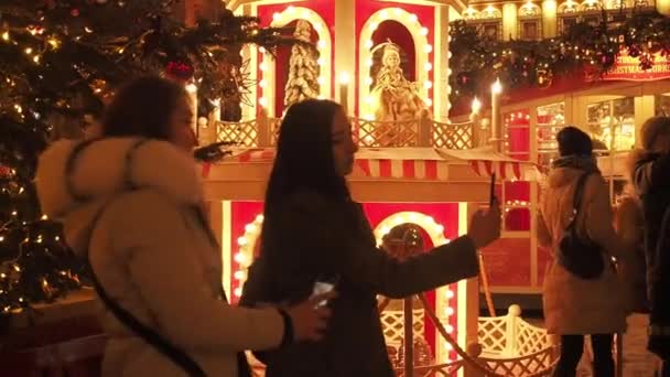 MOSKAU - 17. DEZ 2020: Festliche Neujahrs- und Weihnachtsfeiertage im verschneiten Moskau. Menschenmassen fotografieren und spazieren unter Weihnachtsbäumen auf dem Manegenplatz in der Nähe des Roten Platzes und des Kremls. Hell — Stockvideo