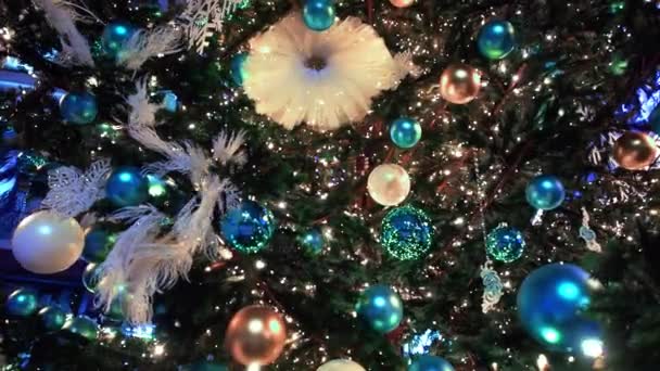 Κλείσε τα φώτα ενός χριστουγεννιάτικου δέντρου που λάμπουν τη νύχτα. Πρωτοχρονιάτικο έλατο με διακόσμηση και φωτισμό. Χριστουγεννιάτικο δέντρο διακοσμήσεις φόντο. Πολλές μεγάλες χρυσές και μπλε μπάλες για έλατο το νέο έτος και — Αρχείο Βίντεο