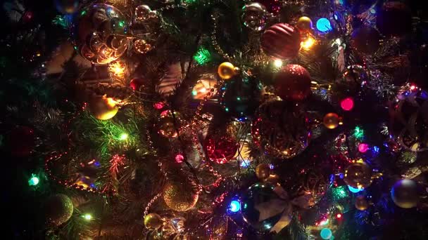Διακοσμημένο φόντο χριστουγεννιάτικο δέντρο από κοντά. Όμορφα και πλούσια διακοσμημένα χριστουγεννιάτικο έλατο στο δρόμο της ευρωπαϊκής πόλης. Κλείσε τα φώτα ενός χριστουγεννιάτικου δέντρου που λάμπουν τη νύχτα. Νέο έτος δέντρο με — Αρχείο Βίντεο