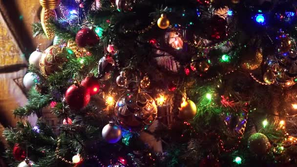 Fondo decorado árbol de Navidad de cerca. Hermoso y rico abeto de Navidad decorado en la calle de la ciudad europea. Cierra las luces de un árbol de Navidad brillando por la noche. Árbol de Año Nuevo con — Vídeo de stock