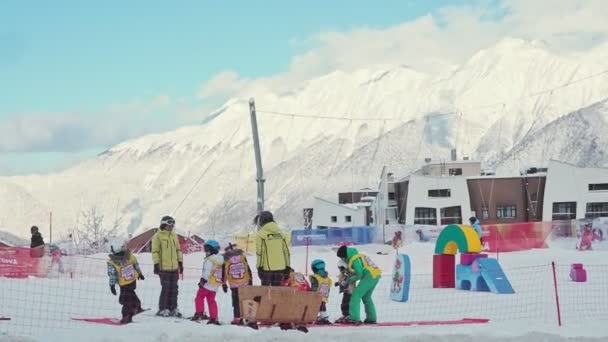 ローザ・クトール、クラスナヤ・ポリアナ、ソチ。ロシアのクラスノダール地方- 2020年2月11日:若いスキーチームのトレーニング。スキーの準備でレッスンで若い子供たちのチームとコーチ. — ストック動画