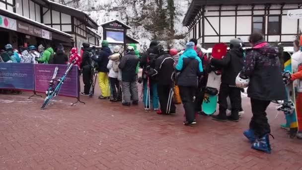 Sochi, Ryssland, 05 februari 2020: Kön till linbanan Olympia på skidorten Rosa Khutor. Många människor i skidåkare och snowboardåkare står i en lång rad på grund av stängda backar under tung snö. — Stockvideo
