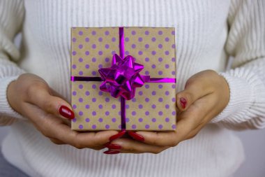 Elinde yeni yıl oyuncakları, hediyeler, saatleri olan bir kız. Noel konsepti. Seçici odak