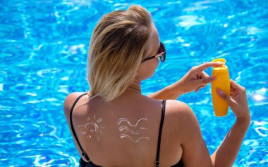 Sırtına güneş kremi sürmüş bir kız. Havuz kenarında dinlenme. Seçici odak