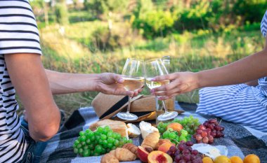 Birbirine aşık çiftler piknikte şarap içer. Seçici odaklanma. Doğa