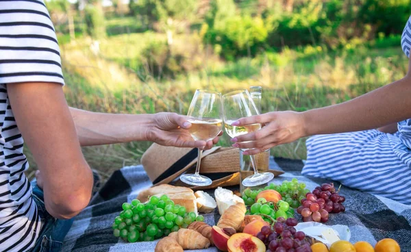 Birbirine aşık çiftler piknikte şarap içer. Seçici odaklanma. Doğa
