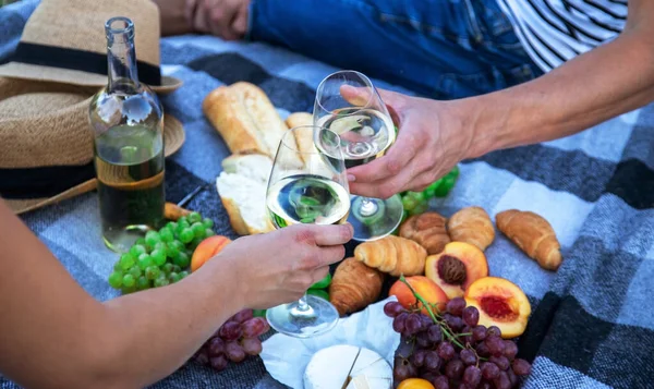 Birbirine aşık çiftler piknikte şarap içer. Seçici odaklanma. Doğa