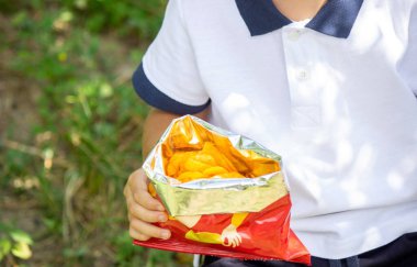 child eats potato chips. Selective focus