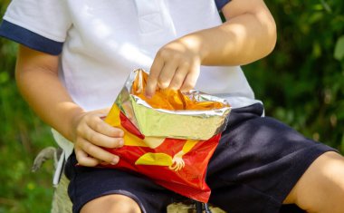 child eats potato chips. Selective focus