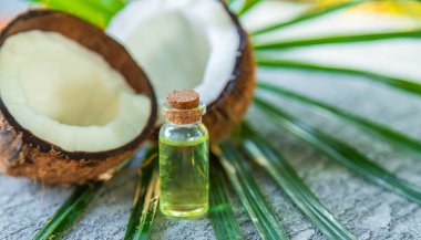 Hindistan cevizi ve yaprakların arka planındaki kavanozda hindistan cevizi yağı. seçici odak